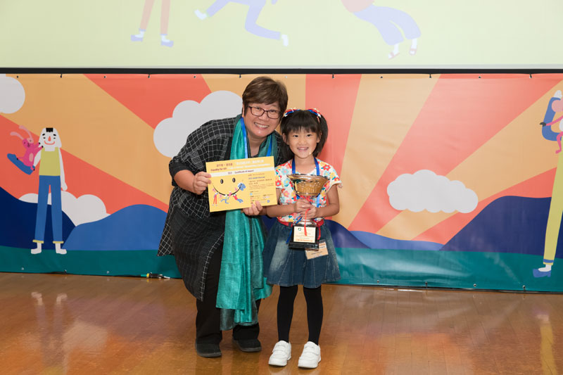書伴我行（香港）基金會社區閱讀發展總監蔡淑玲女士頒發亞軍獎盃予黃雋恩小朋友。